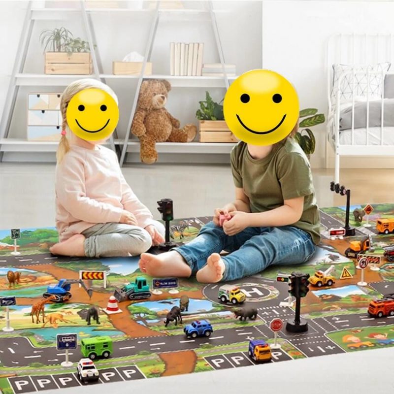 Deux enfants jouants sur un tapis de circuit de voiture avec jouets
