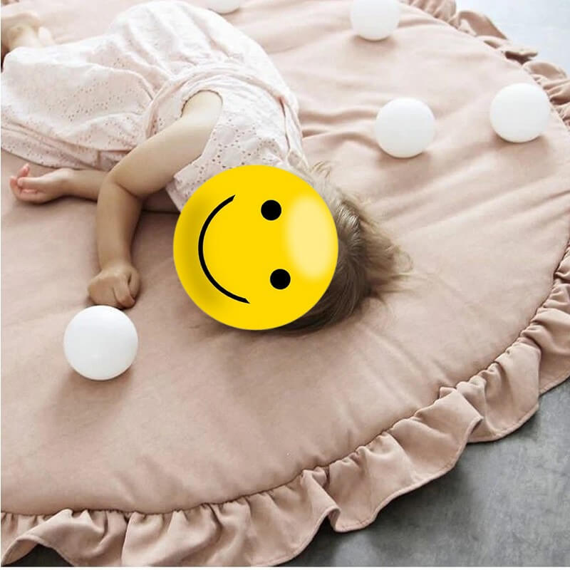 Petite fille allongée sur un tapis de chambre pour bébé rond et doux