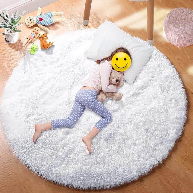 Petite fille dormant sur un tapis blanc pour chambre de bébés