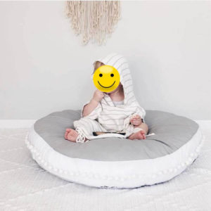 Bébé assis sur un tapis bébé epais gris