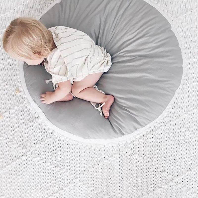 Enfant sur un tapis bébé epais gris