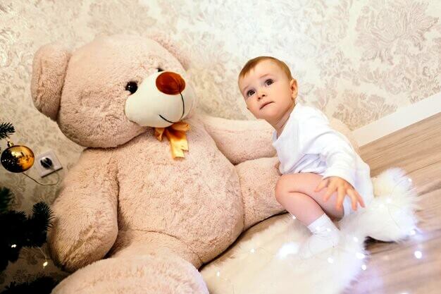 Bébé avec peluche géante