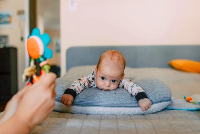 Bébé allongé sur le ventre sur un tapis d'éveil
