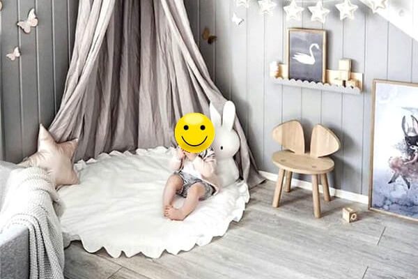 Bébé dans sa chambre assis sur un tapis de chambre pour bébé rond et doux