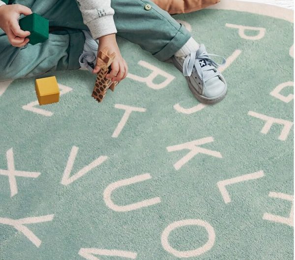 Enfant jouant sur un tapis rond avec alphabet pour chambre d'enfants