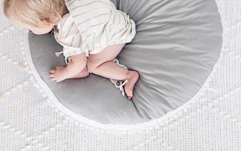 Enfant sur un tapis bébé epais gris