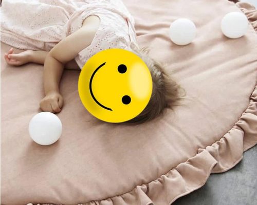 Petite fille allongée sur un tapis de chambre pour bébé rond et doux